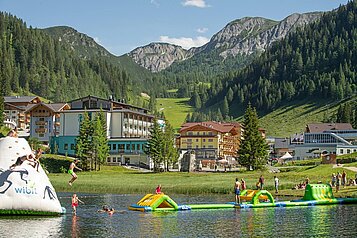 Im Familienhotel Zauchenseehof im Salzburger Land gibt es im Sommer aufblasbare Wasserspiele mitten im See