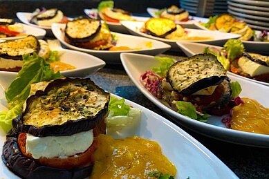 Frisch zubereitete Speisen, Aubergine mit Tomate Mozzarella angerichtet mit Salat im Familienhotel Family Club Harz.