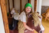 Kind reitet auf Holzpferd im liebevoll gestalteten Indoor-Spielbereich des Hotel Engel im Schwarzwald