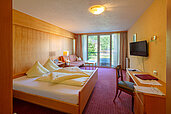 Ein Doppelzimmer mit Blick ins Grüne im Familienhotel Sonne Bezau Vorarlberg.