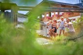 Eine Familie auf einer Hängebrücke auf dem Spielplatz im Familienhotel Amiamo im Salzburger Land