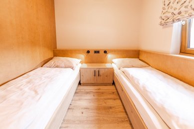 Kinderzimmer mit zwei Einzelbetten im Familienhotel Das Bayrischzell, hell und freundlich eingerichtet