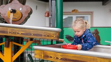 Mädchen planscht auf dem Wasserspielplatz vom Kaiserhof in Berwang