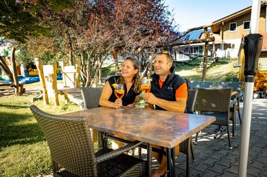 Eltern genießen Aperol Spritz auf der Terrasse des Familienhotels Krone im Allgäu.