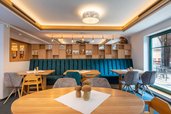 Moderne Stube mit Holztischen und Sitzbänken im Familienhotel Ottonenhof.