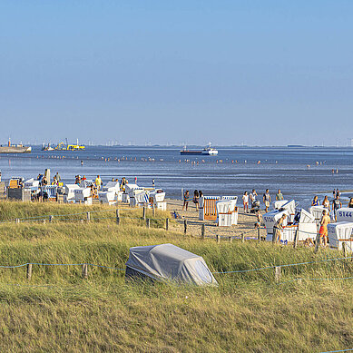 In der Familienlagune an der Nordsee in Büsum ist das Watt, in dem viele Personen im Horizont spazieren.