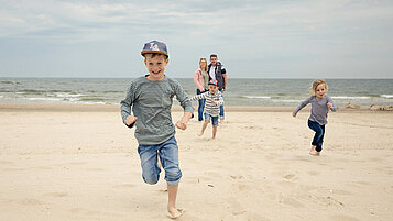 Eine Familie genießt die Zeit am Strand des Familien Wellness Hotel Seeklause an der Ostsee.