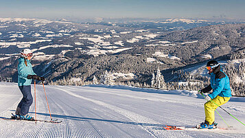 Skifahrer in Kaernten im Winter. Das Lavanttal befindet sich im Hintergrund.