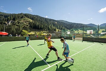 Kinder spielen Fussball im Outdoorbereich im Familienhotel Zauchenseehof im Salzburger Land