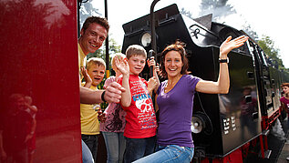 Familie fährt beim Familienurlaub im Harz mit der historischen Brockenbahn.