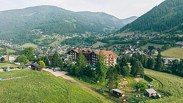 Aufnahme des Familienhotels Kirchheimerhof in Kärnten mit einer großen Grünfläche rund um das Hotel.
