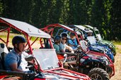 Gäste fahren mit bunten Buggys durch die Natur rund um das Familien Resort Petschnighof in Kärnten.