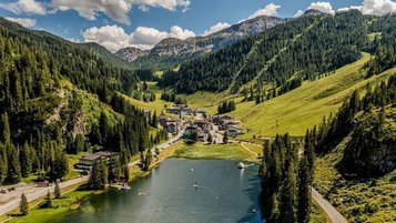 Blick über den Zauchensee auf das Familienhotel Zauchenseehof im Salzburger Land