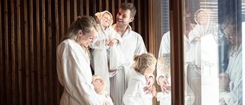 Familie mit drei Kindern entspannt im Wellnessbereich des Familienhotels