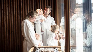 Familie mit drei Kindern entspannt im Wellnessbereich des Familienhotels