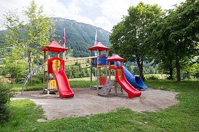 Großer Spielplatz mit Rutschen, Klettertürmen und Sandkasten im Familienhotel Bavaria im Allgäu.