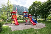 Großer Spielplatz mit Rutschen, Klettertürmen und Sandkasten im Familienhotel Bavaria im Allgäu.