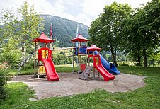Großer Spielplatz mit Rutschen, Klettertürmen und Sandkasten im Familienhotel Bavaria im Allgäu.