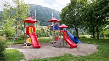 Großer Spielplatz mit Rutschen, Klettertürmen und Sandkasten im Familienhotel Bavaria im Allgäu.