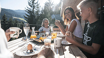 Familie genießt ihr privates Frühstück im Familienurlaub im Luxuschalet in Südtirol.