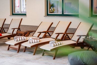 Bequeme Relaxliegen mit Handtüchern im Wellnessbereich des Familienhotels Bruckwirt laden zum Entspannen ein.