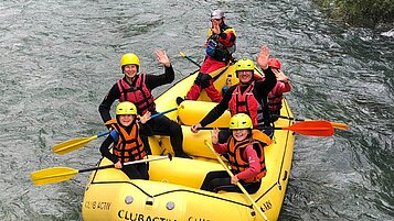 Familie mit Teenagern beim Rafting auf dem Fluss in Südtirol.