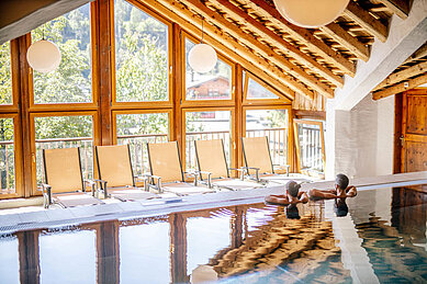 Schwimmbad mit großen Panoramafenster im Familienhotel Das Hopfgarten in Tirol.