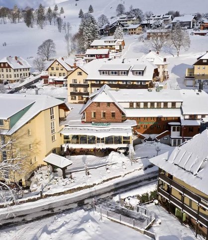 Das Familienhotel Engel im Schwarzwald umgeben von verschneiter Landschaft.
