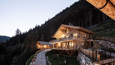 Ansicht der Mons Silva Private Luxury Chalets in Südtirol am Abend.