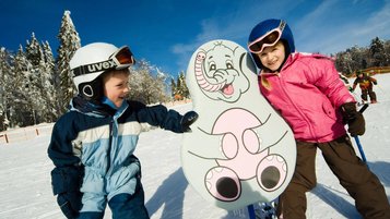 Zwei Kinder auf Skiern im Kinder Ski-Zirkus im Bayerischen Wald. 