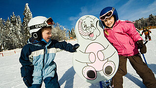 Zwei Kinder auf Skiern im Kinder Ski-Zirkus im Bayerischen Wald. 