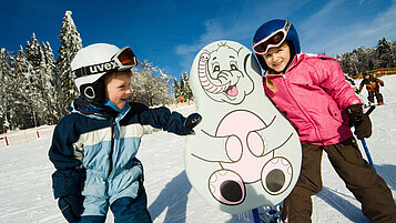 Zwei Kinder auf Skiern im Kinder Ski-Zirkus im Bayerischen Wald. 