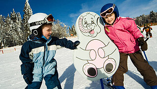Zwei Kinder auf Skiern im Kinder Ski-Zirkus im Bayerischen Wald. 
