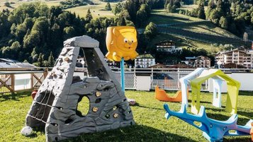 Outdoor-Spielplatz mit Klettergerüst und Rutsche im Wellness- & Familienhotel Egger im Salzburger Land.