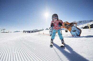 Kind steht auf Skiern auf dem frisch präparierten Übungsgelände, welches sich direkt am Alpenhotel Kindl befindet, der Kinderskischule im Familienurlaub in Tirol.