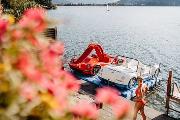 Badestrand mit Tretbooten und Zugang zum See im Familienhotel Amiamo im Salzburger Land.