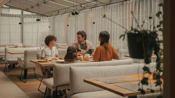 Familie mit zwei Kindern beim Essen im Restaurant im Hotel Engel Gourmet & Spa in Südtirol