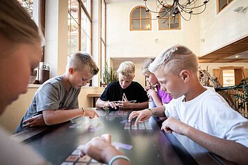 Teens spielen im Happy-Club ein Gemeinschaftsspiel im Familienhotel Alphotel Tyrol Wellness & Family Resort in Südtirol.