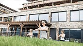 Drei Frauen beim Yogaunterricht für Erwachsene in der Natur im Familienhotel Allgäuer Berghof.