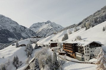 Das Familienhotel Alphotel im Allgäu umgeben von einer winterlichen Berglandschaft