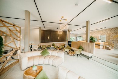Die stilvolle Lounge mit Naturmaterialien macht den Aufenthalt im Familienhotel Friedrichshof besonders gemütlich.