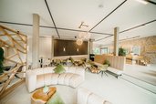 Die stilvolle Lounge mit Naturmaterialien macht den Aufenthalt im Familienhotel Friedrichshof besonders gemütlich.