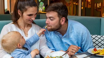 Familie beim Essen im Restaurant im Familienhotel Elldus Resort im Erzgebirge. 