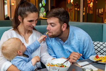 Familie beim Essen im Restaurant im Familienhotel Elldus Resort im Erzgebirge. 