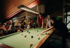 Teens verbringen gemeinsam Zeit beim Billardspielen im Teens-Club des Hotel Sonngastein im Salzburger Land.