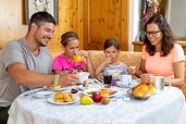 Eine Familie frühstückt im Restaurant im Adler Familien- & Wohlfühlhotel in Tirol.