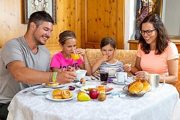 Eine Familie frühstückt im Restaurant im Adler Familien- & Wohlfühlhotel in Tirol.