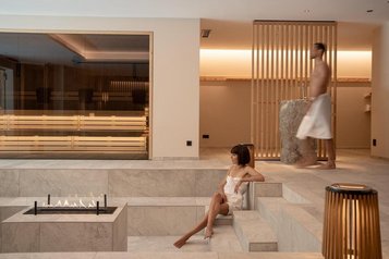 Blick in den Spa- und Ruhebereich mit Feuerstelle und angrenzender Sauna im Hotel Bella Vista in Südtirol.