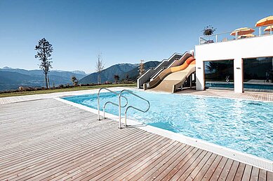 Outdoor Pool mit großer Rutsche im Family Home Alpenhof.