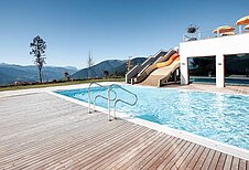 Outdoor Pool mit großer Rutsche im Family Home Alpenhof.